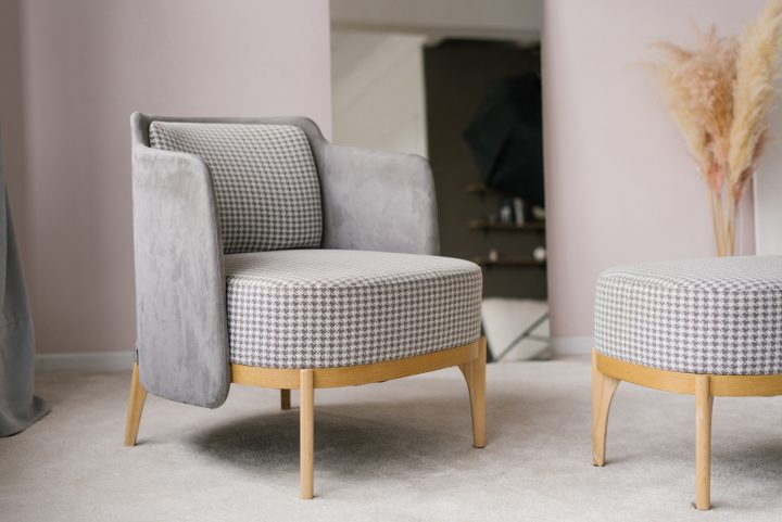 Grey armchair in a modern living room with a mirror